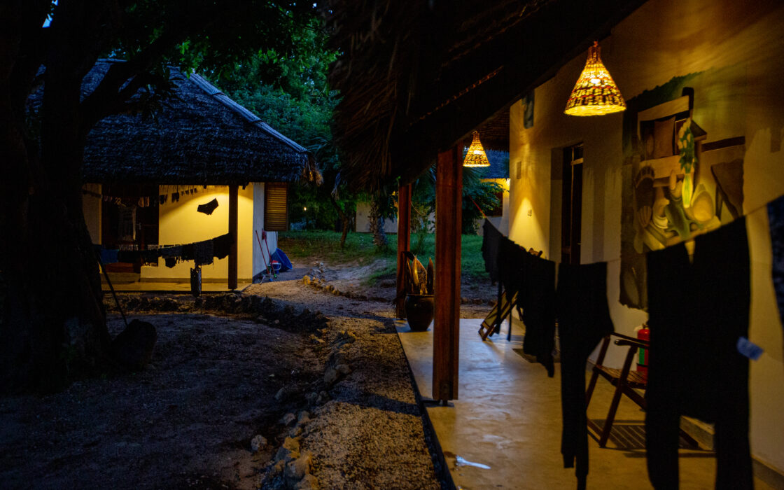 Two bungalows at night, with dim lights at their entrances